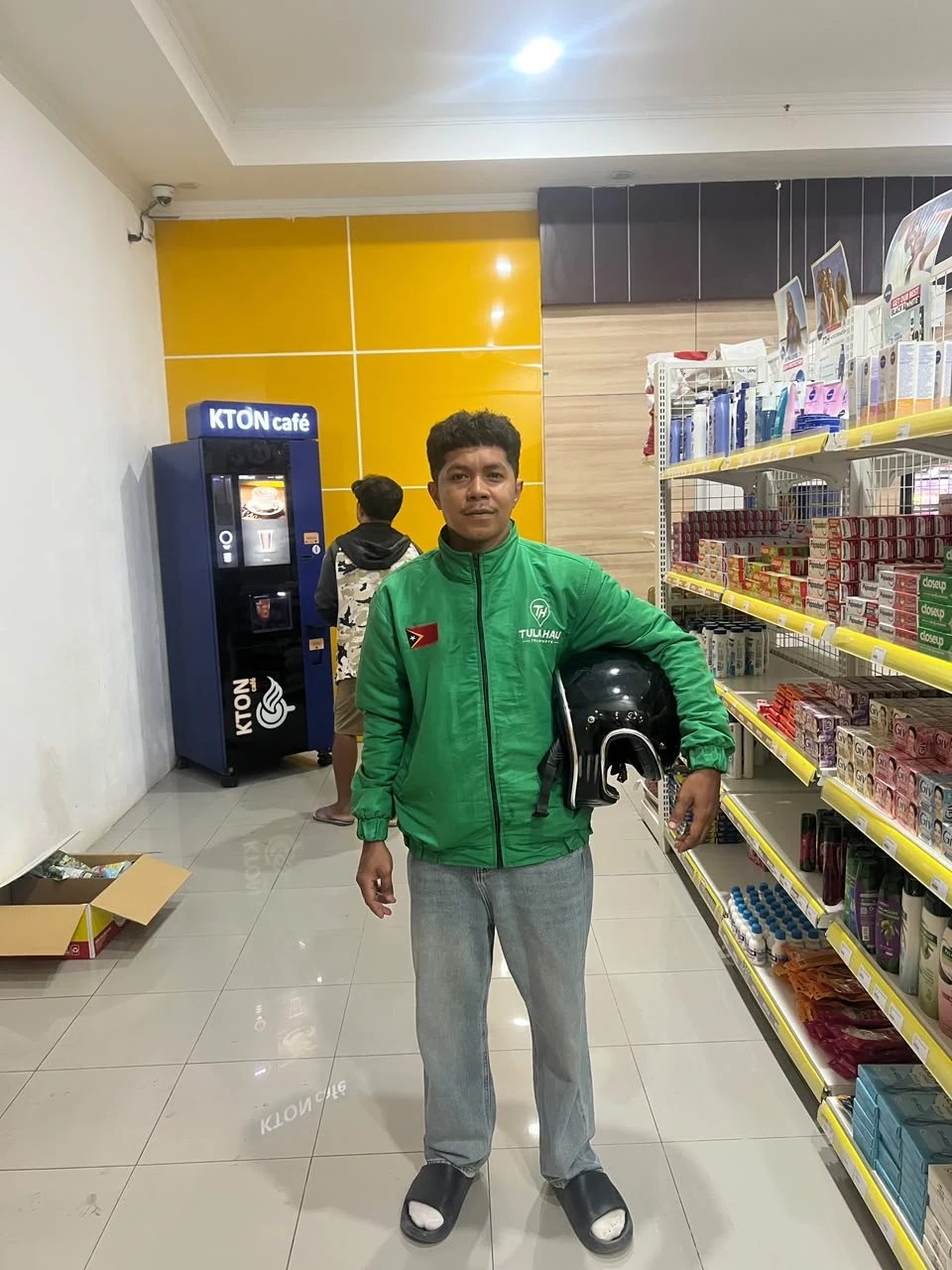 A TULA-HAU driver holding a helmet inside a shop